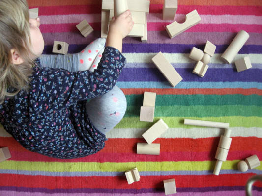 Dieťa si skladá z drevených kociek