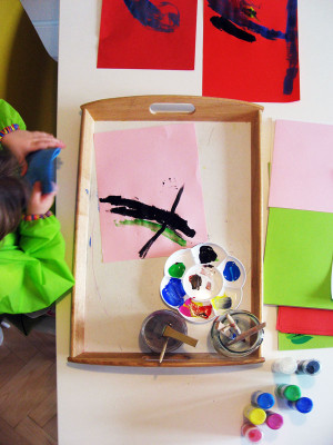 Dieťa maľuje štetcami na papier
