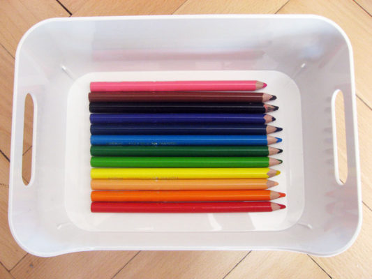 Detské farebné ceruzky v nádobe usporiadané podľa farieb dúhy