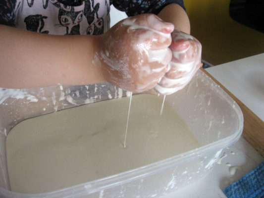 Dieťa robí pokus s kukuričným škrobom a vodou