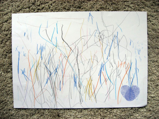 Dieťa experimentovalo s farbičkami na papieri a nakreslilo krátke nespojité expresívne čiary